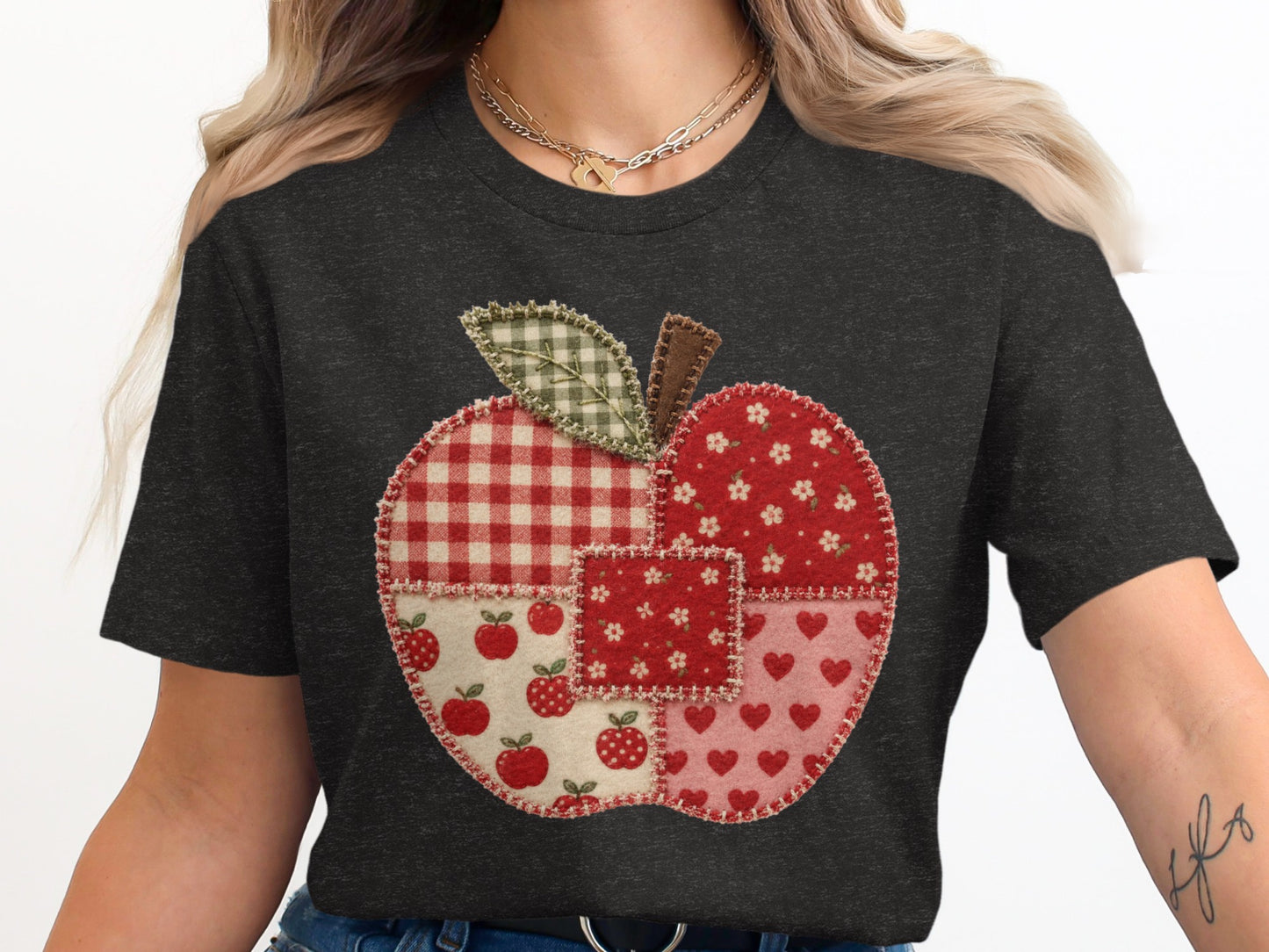 Dark gray t-shirt with a patchwork apple design in red and white patterns.