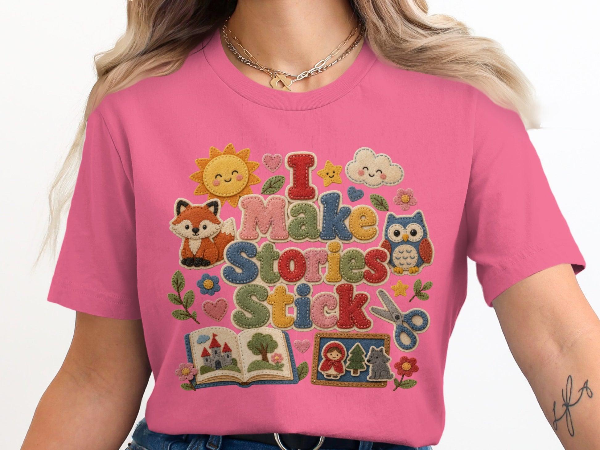 Pink t-shirt with "I Make Stories Stick" text and whimsical illustrations.