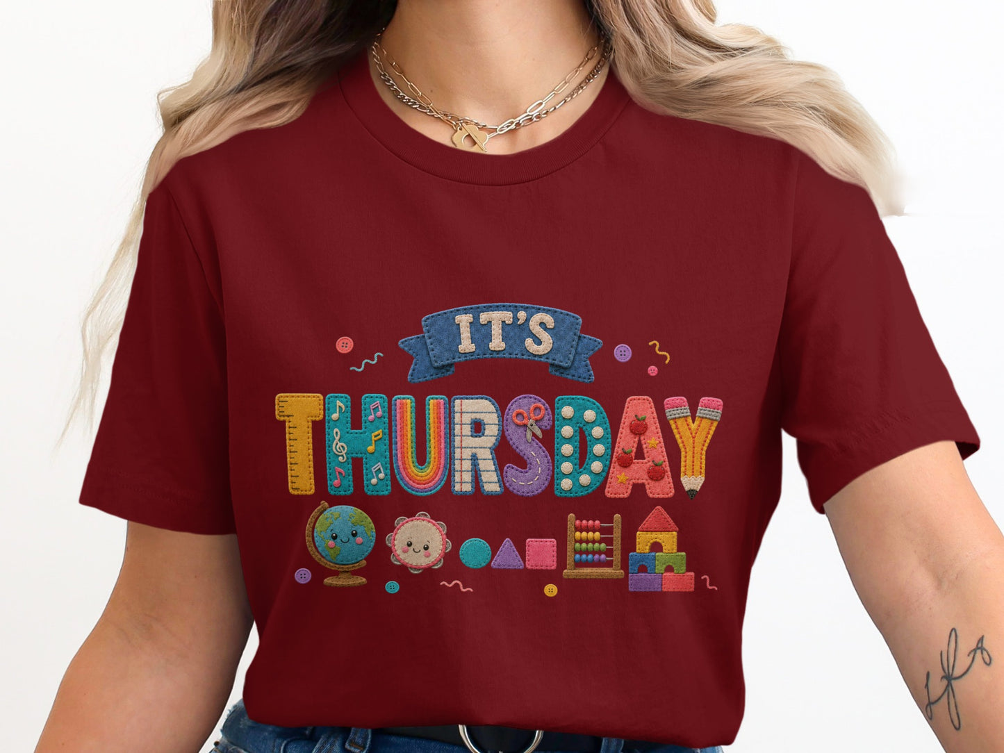Maroon t-shirt with "IT'S THURSDAY" in colorful letter appliques and school icons.