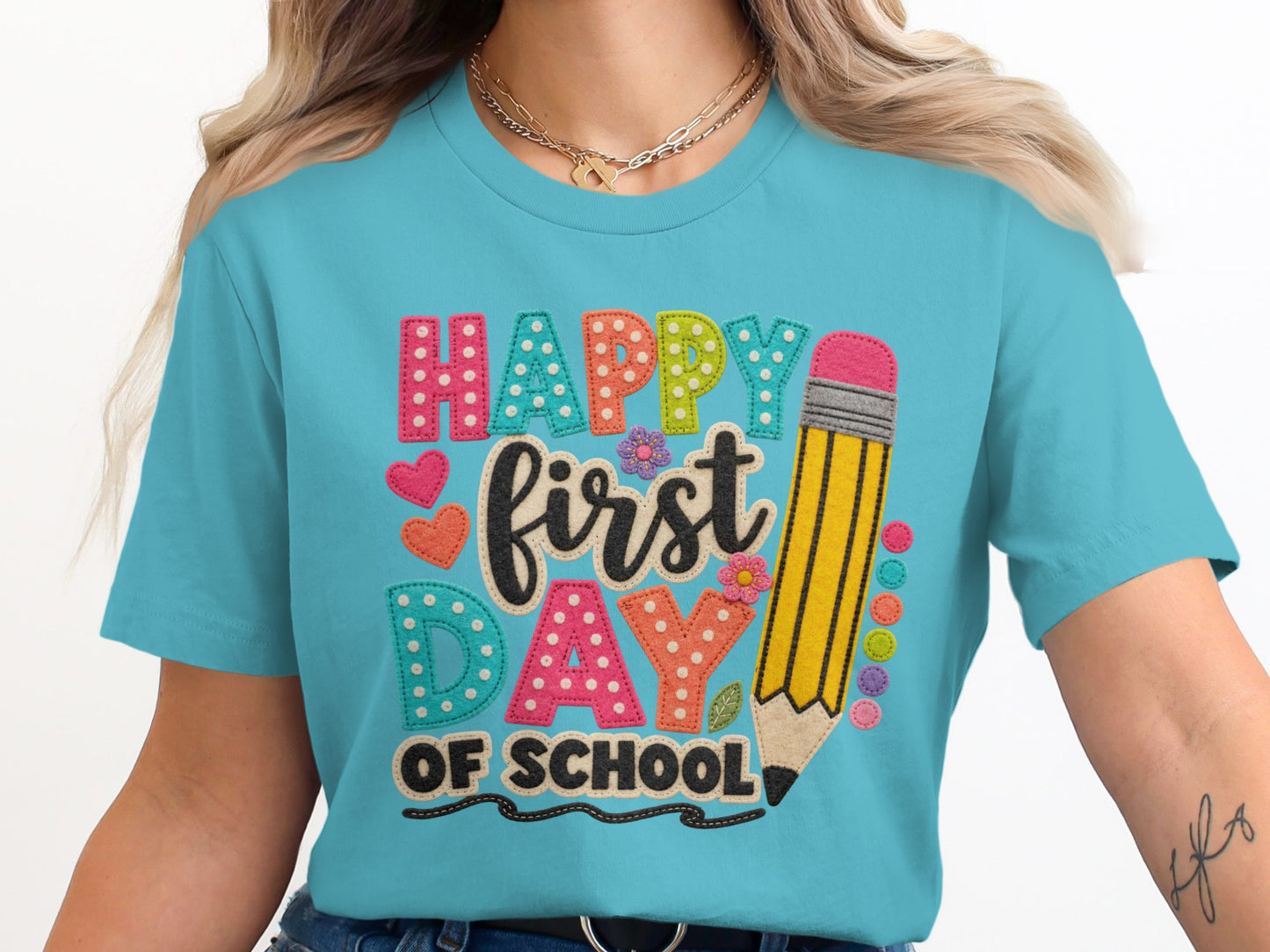 Turquoise t-shirt with "Happy First Day of School" text and pencil graphic.