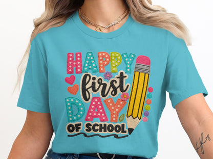 Turquoise t-shirt with "Happy First Day of School" text and pencil graphic.
