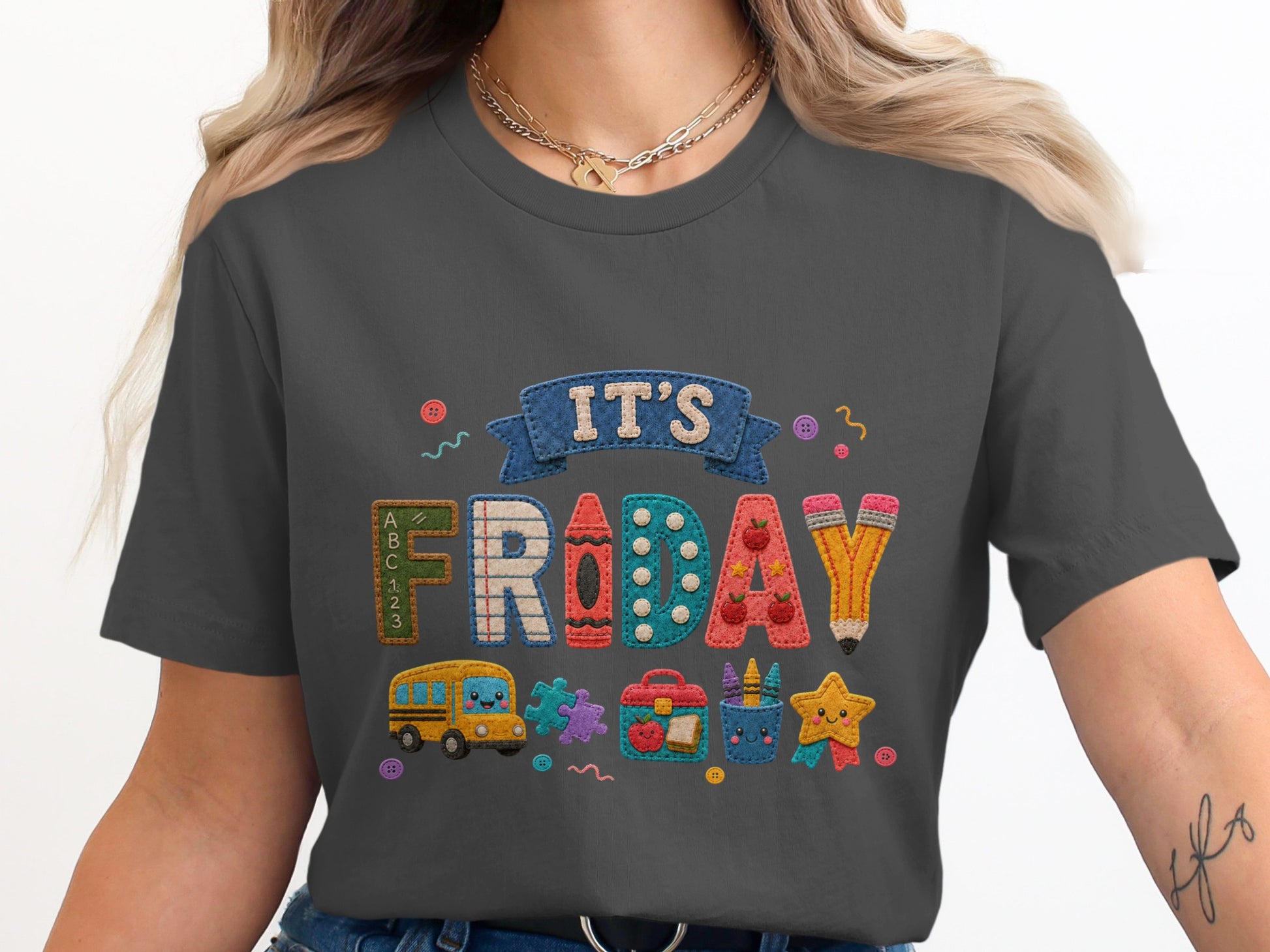 Grey t-shirt with embroidered "IT'S FRIDAY" and school-themed graphics.