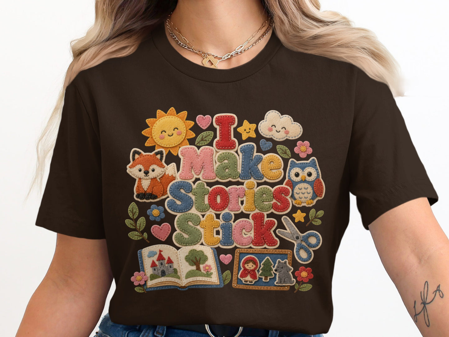 Brown t-shirt with "I Make Stories Stick" text and storybook graphics.