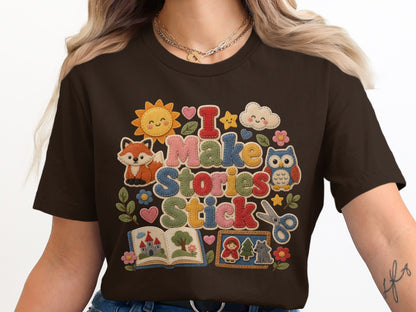 Brown t-shirt with "I Make Stories Stick" text and storybook graphics.