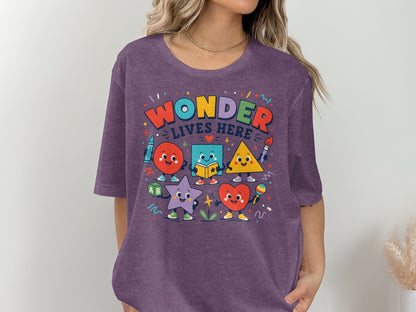 Purple t-shirt with "Wonder Lives Here" text and cute anthropomorphic shapes.