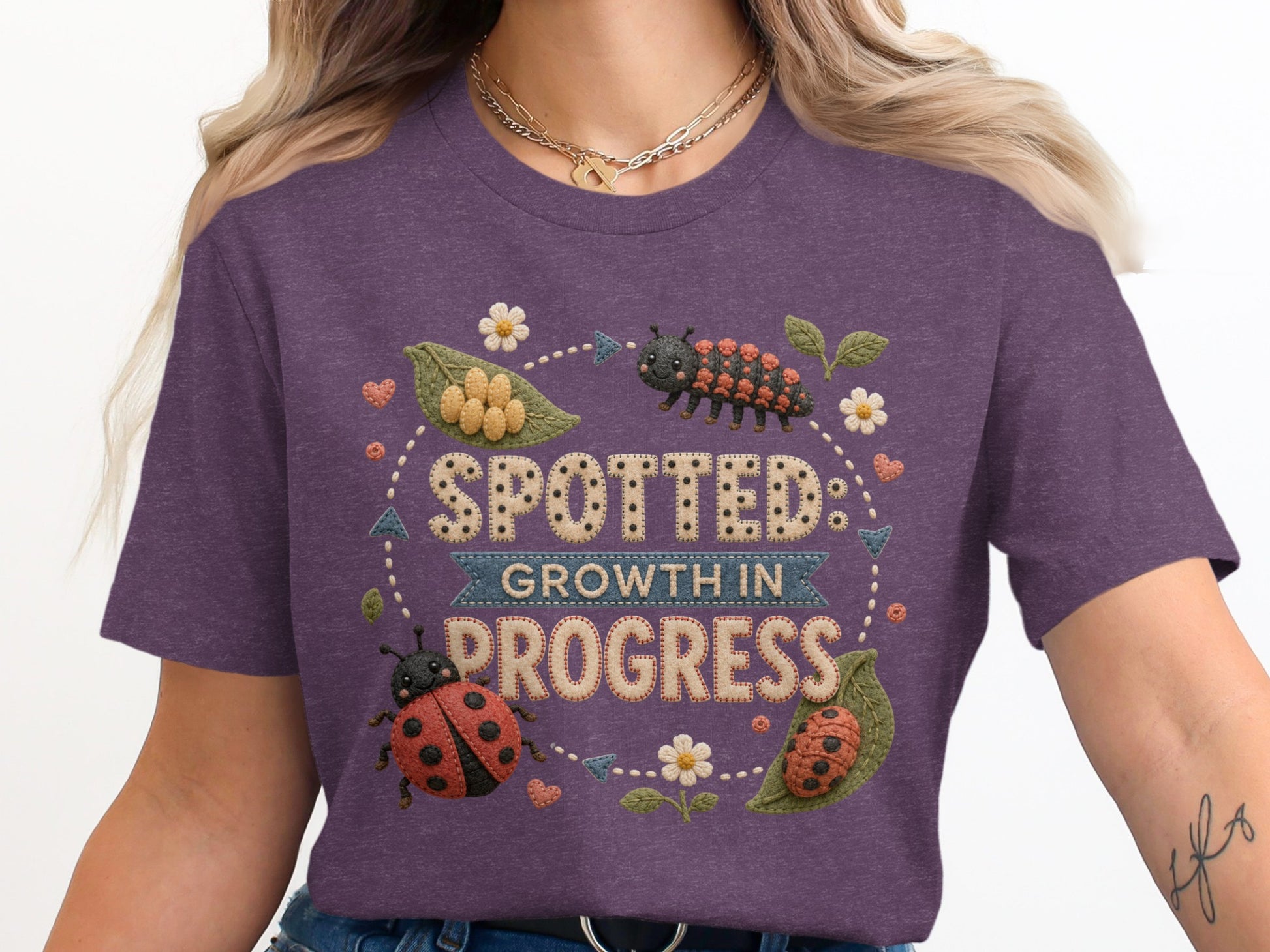 Purple t-shirt with "Spotted Growth in Progress" text and ladybugs.