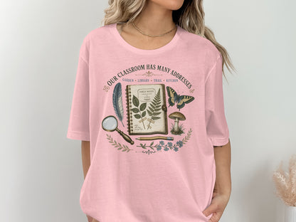 Pink t-shirt with nature-themed graphic and text "Our Classroom Has Many Addresses".