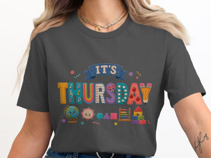 Dark grey t-shirt with "IT'S THURSDAY" text and school themed graphics.