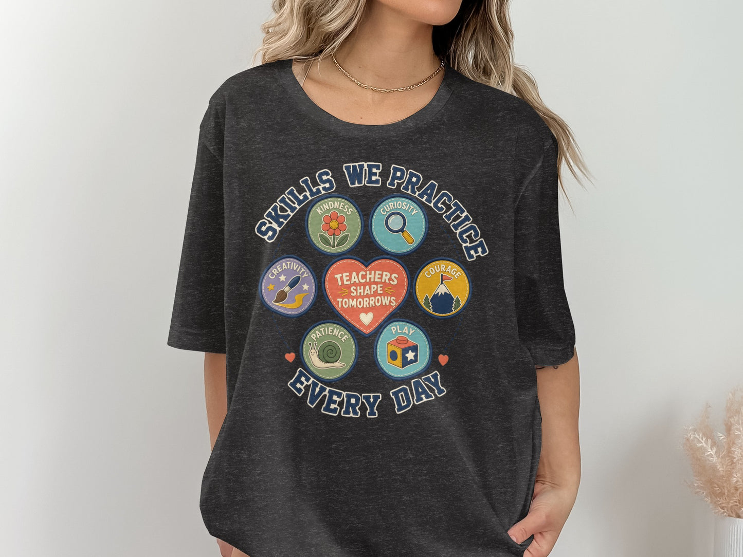 Charcoal t-shirt with "Skills We Practice Every Day" graphic featuring classroom and kindness icons.