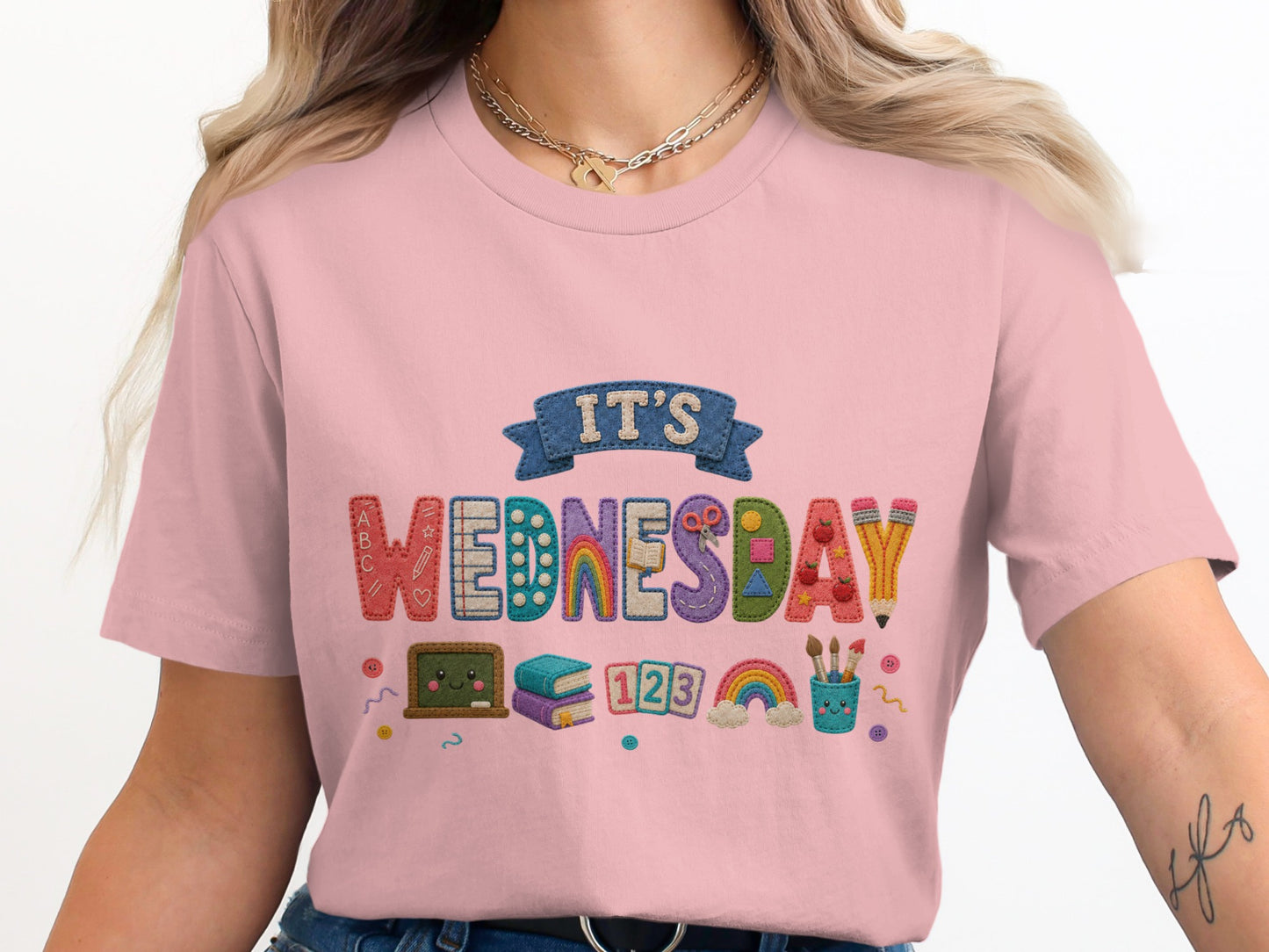Pink t-shirt with "It's Wednesday" embroidered with school-themed embellishments.