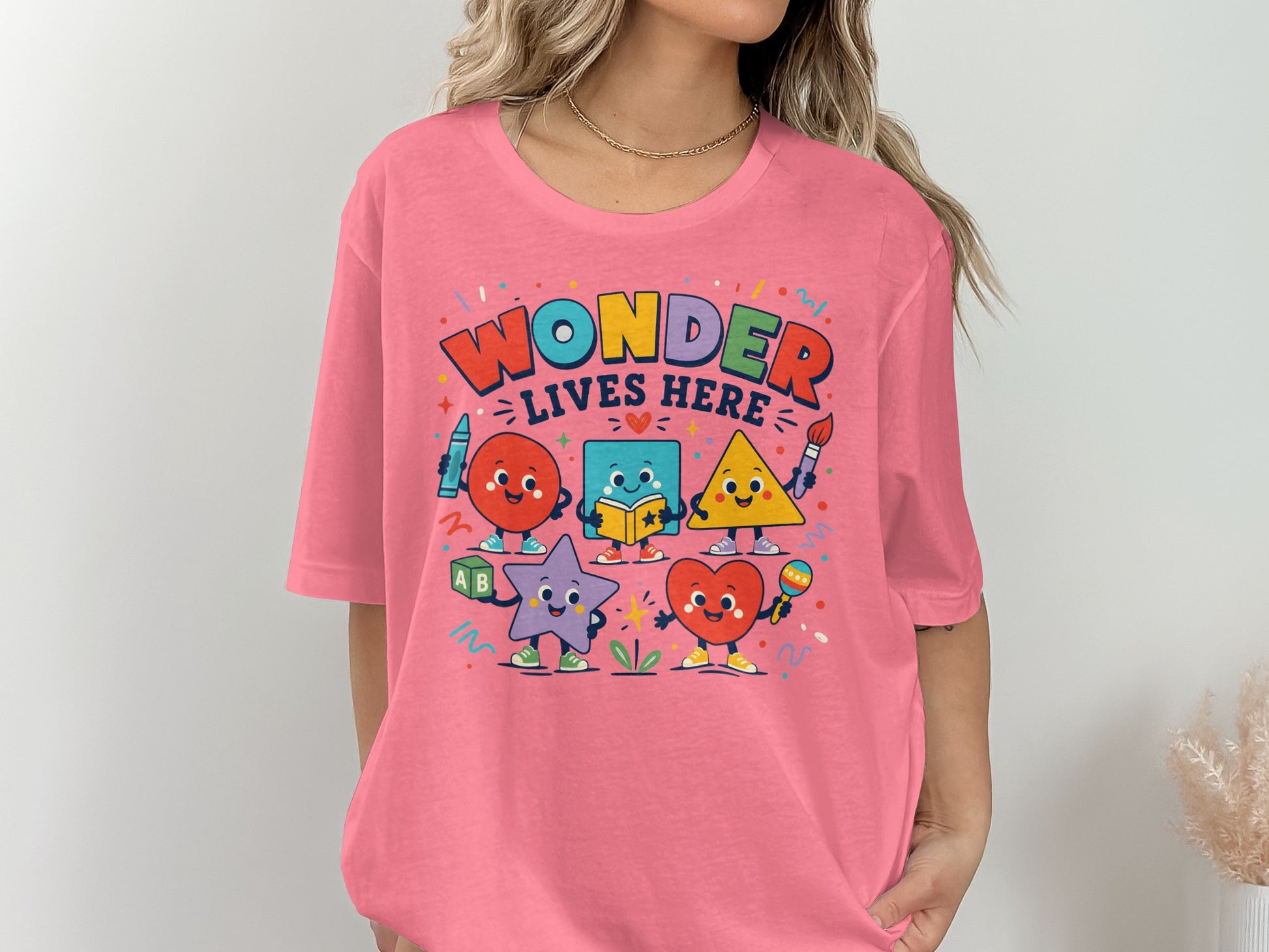 Graphic tee with "Wonder Lives Here" text and playful cartoon shapes.