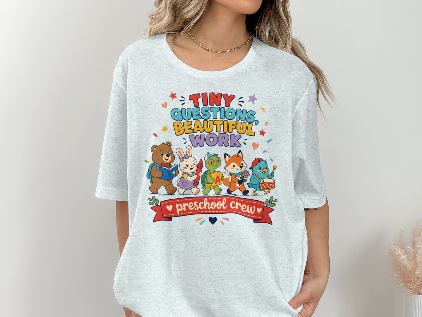 Cute cartoon animals with "Tiny Questions Beautiful Work preschool crew" text on t-shirt.