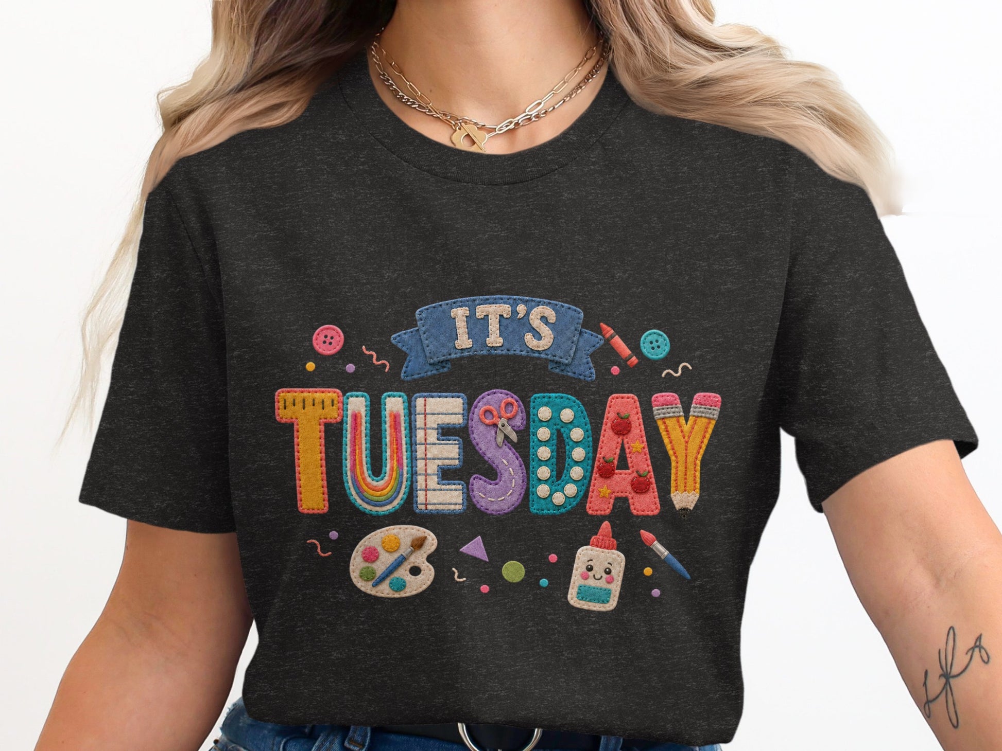 Dark t-shirt with "IT'S TUESDAY" in embroidered classroom applique letters.