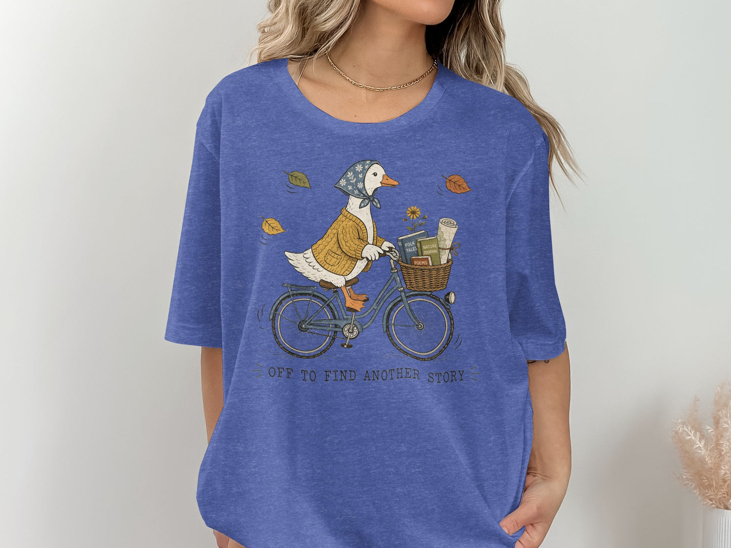 Duck wearing a sweater and bandana rides a bicycle with books and flowers.