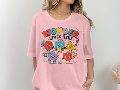 Pink t-shirt with "Wonder Lives Here" text and cartoon shapes.