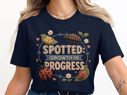 Navy t-shirt with "Spotted: Growth in Progress" text and ladybugs and caterpillars.