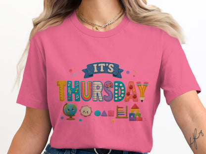 Pink t-shirt with "IT'S THURSDAY" text and school-themed classroom graphics.