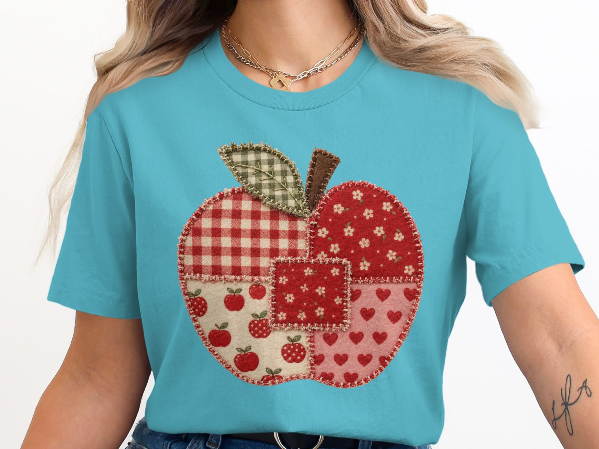 Patchwork apple graphic on a light blue t-shirt.