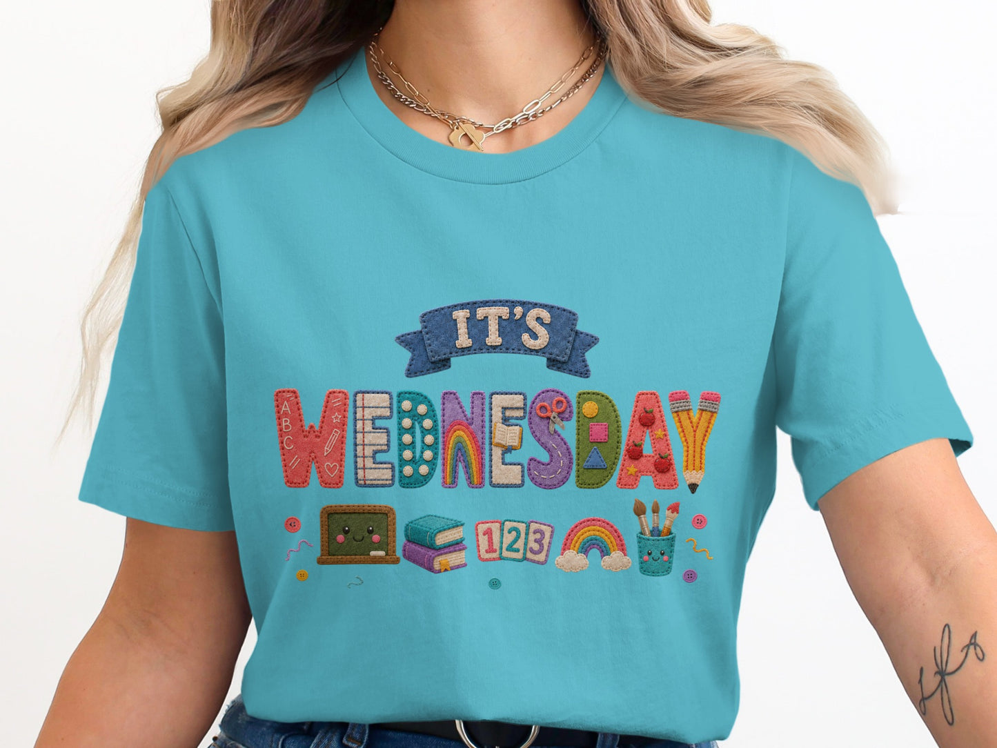 Turquoise t-shirt with embroidered "IT'S WEDNESDAY" and classroom graphics.