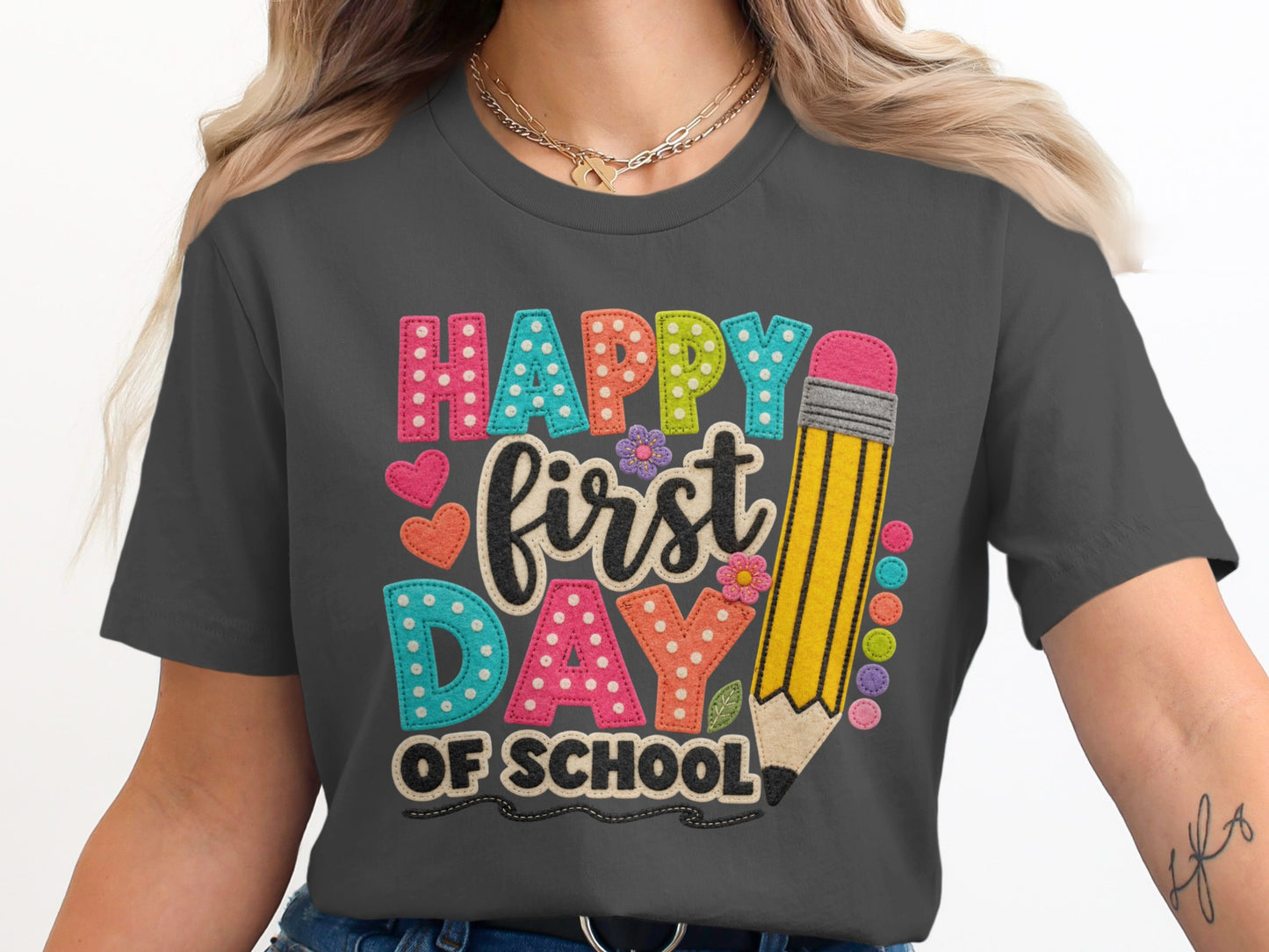 Grey t-shirt graphic with "Happy first DAY OF SCHOOL" text and a pencil.