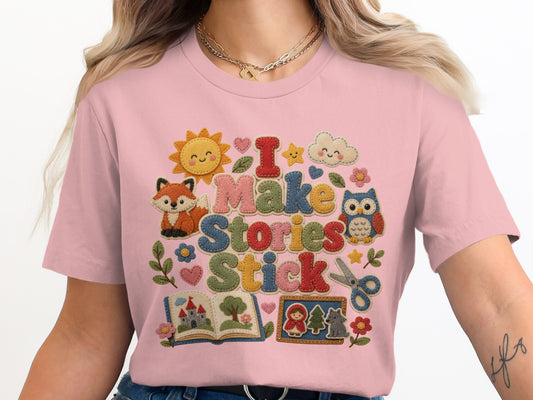 Pink t-shirt with "I Make Stories Stick" text and woodland-themed appliqués.