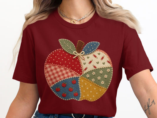 Maroon t-shirt with a quilted apple applique featuring various patterns and apple designs.