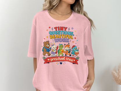 Pink t-shirt with "Tiny Questions, Beautiful Work, Preschool Crew" and cartoon animals wearing backpacks.