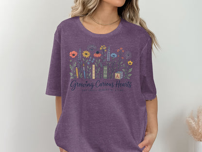 Purple t-shirt with floral design and text "Growing Curious Hearts".