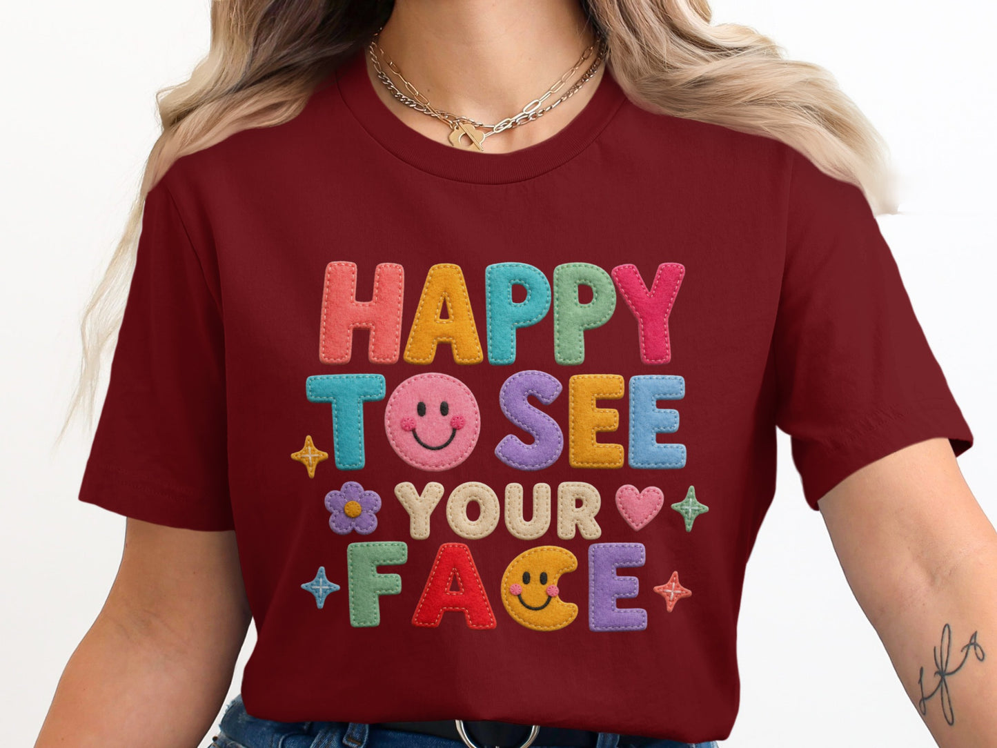 Maroon t-shirt with "HAPPY TO SEE YOUR FACE" text and colorful smiley face graphics.