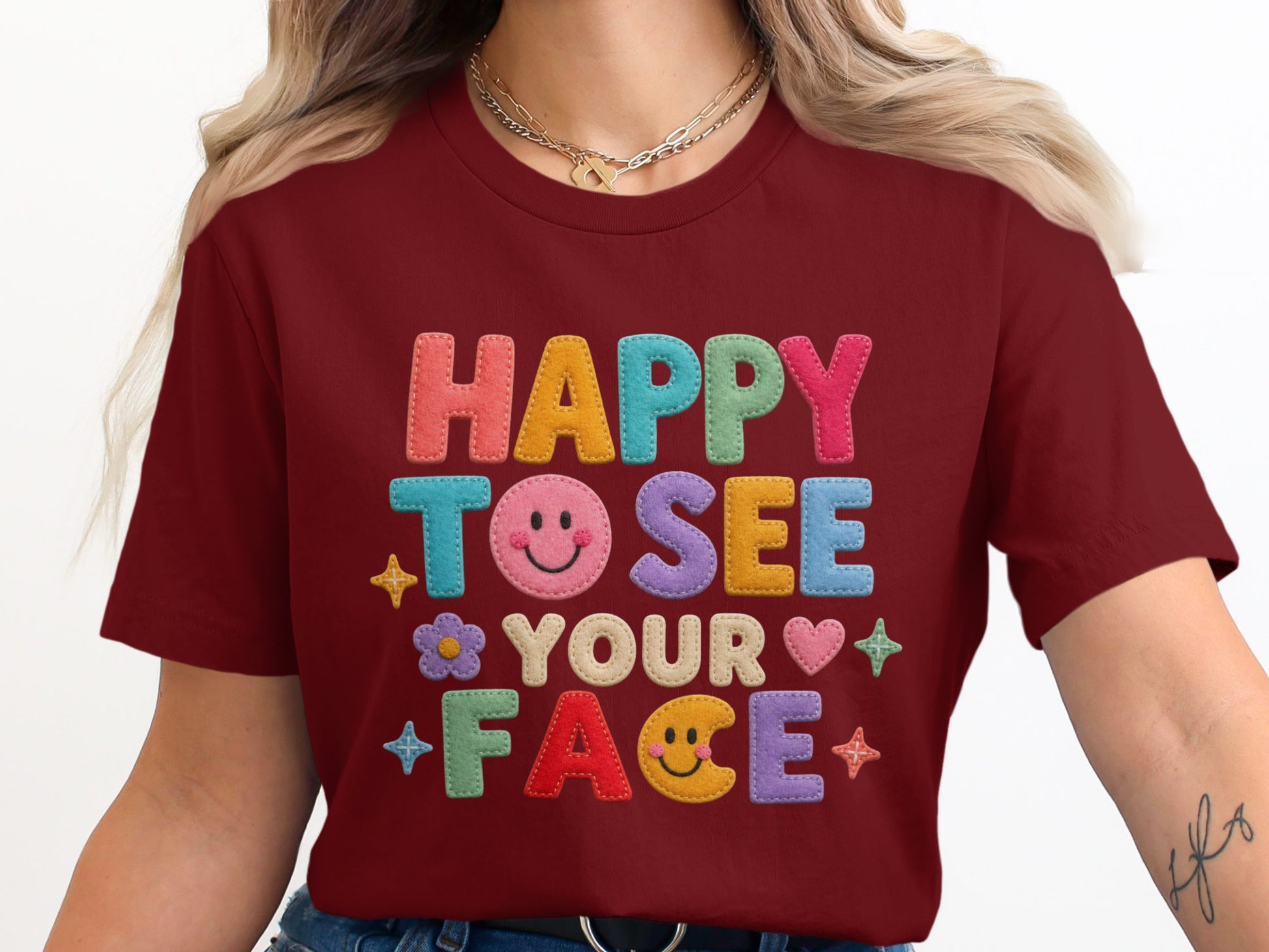 Maroon t-shirt with "HAPPY TO SEE YOUR FACE" text and colorful smiley face graphics.