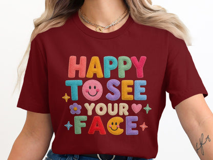 Maroon t-shirt with "HAPPY TO SEE YOUR FACE" text and colorful smiley face graphics.