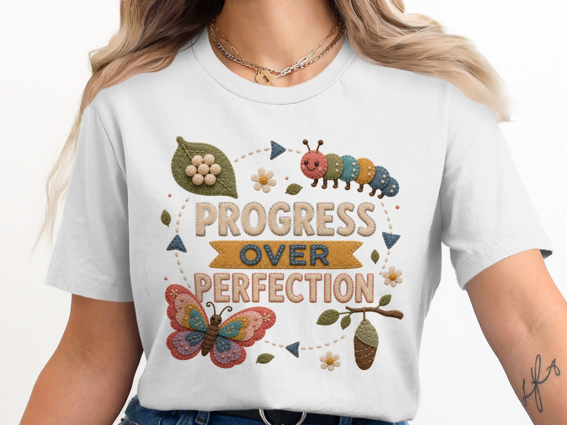 White t-shirt with "Progress Over Perfection" text, caterpillar, butterfly, and chrysalis graphic.