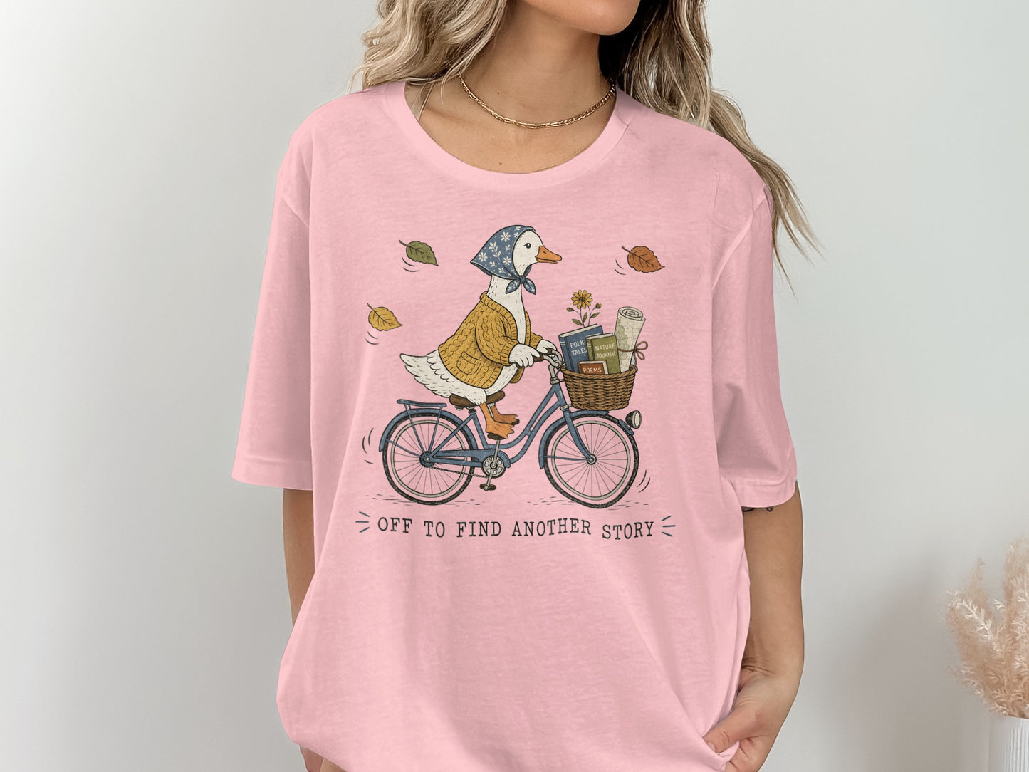 Illustration of a duck on a bicycle with books and flowers in the basket and text "off to find another story".