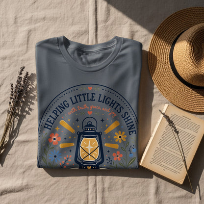 Grey t-shirt with a lantern design and text "Helping Little Lights Shine".