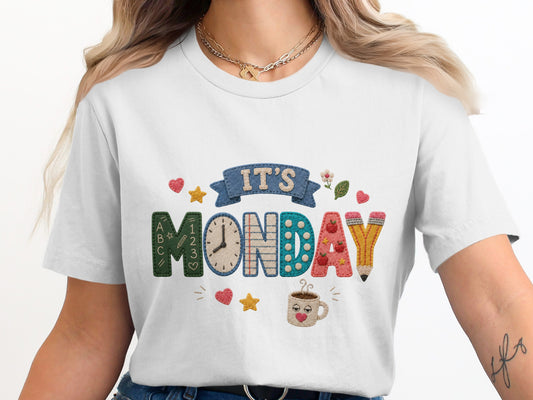 White t-shirt with "IT'S MONDAY" graphic featuring school-themed elements.