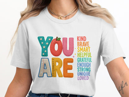 White t-shirt with "YOU ARE" and positive attributes like kind, brave, smart, loved.