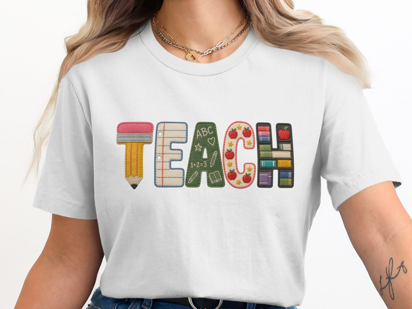 White t-shirt with the word TEACH featuring school supply graphics.