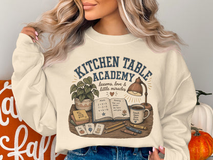 Sweatshirt graphic: Kitchen Table Academy lessons, love & little miracles with school supplies.