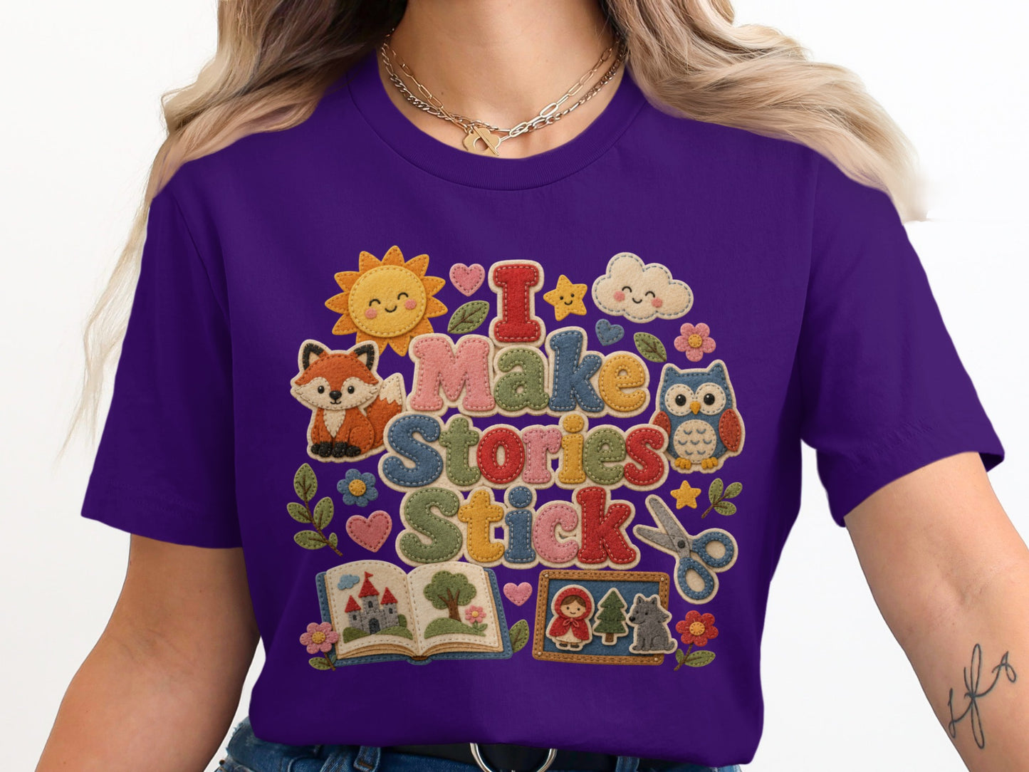 Purple t-shirt with "I Make Stories Stick" design featuring cute characters.