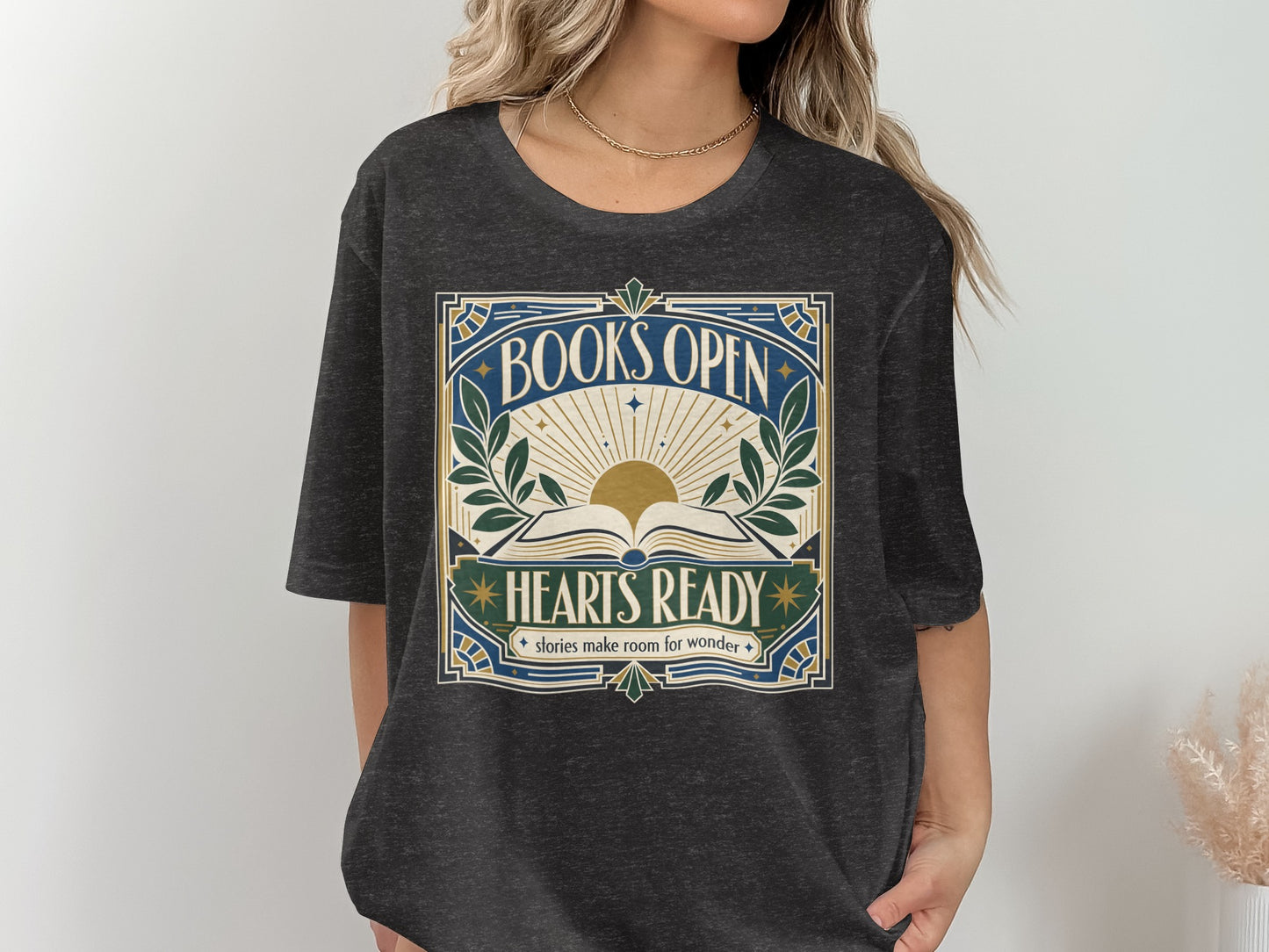 Dark t-shirt with "BOOKS OPEN HEARTS READY stories make room for wonder" graphic.