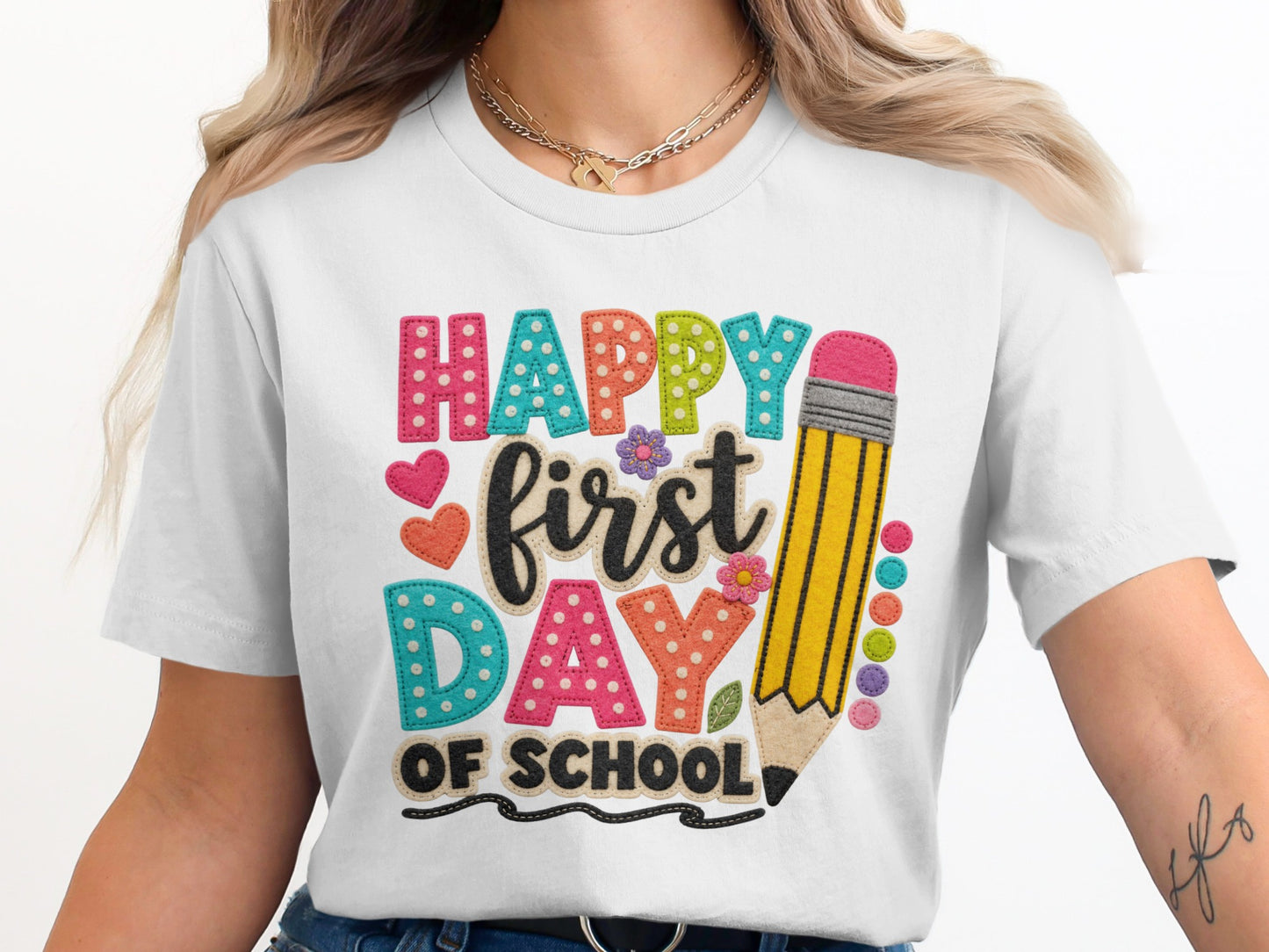 White t-shirt with "Happy First Day of School" text and pencil graphic.