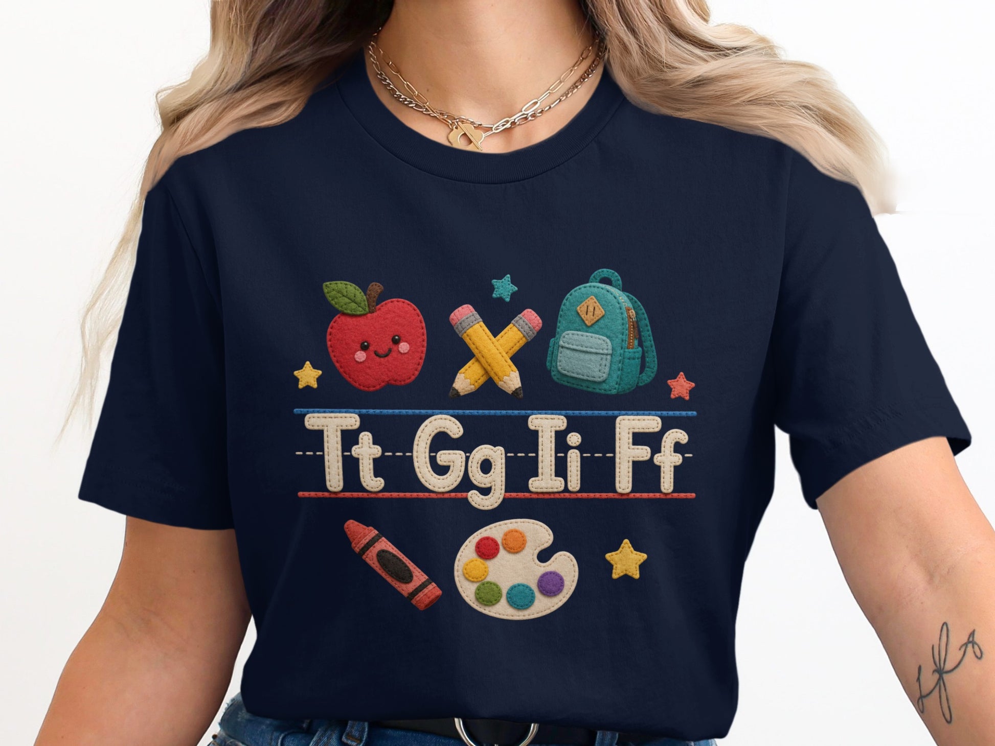 Navy t-shirt with embroidered school supplies and alphabet letters.