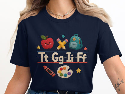 Navy t-shirt with embroidered school supplies and alphabet letters.