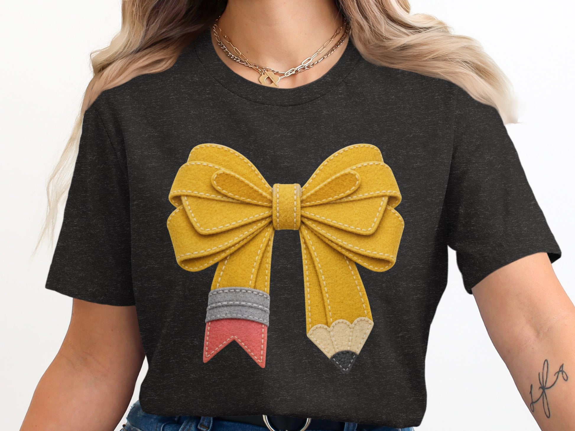 Dark t-shirt with a yellow pencil-shaped bow graphic design.