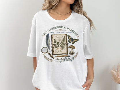 White t-shirt with "Our Classroom Has Many Addresses" text and nature illustrations.