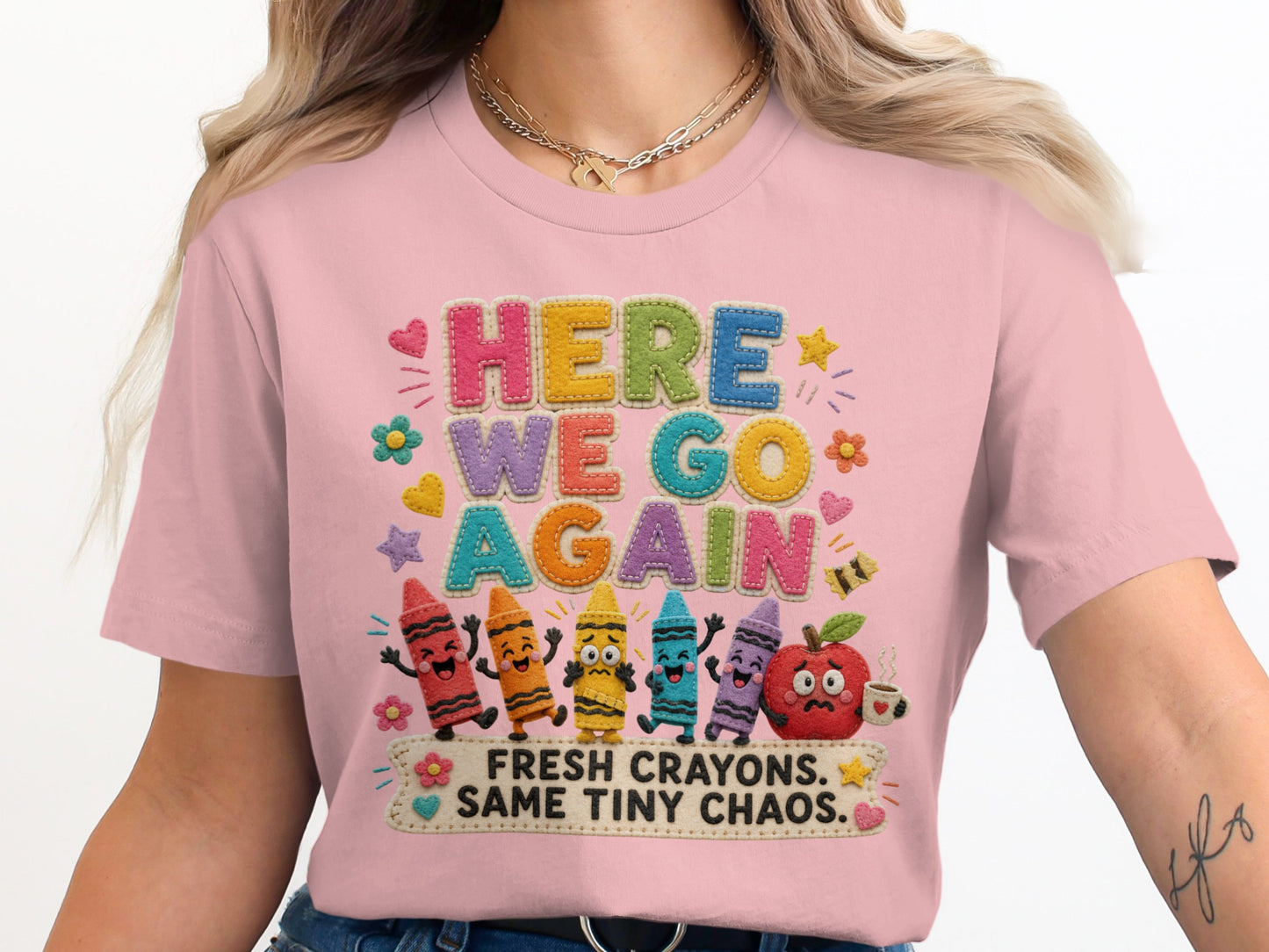 Pink t-shirt with "HERE WE GO AGAIN FRESH CRAYONS. SAME TINY CHAOS." text and cartoon crayons.