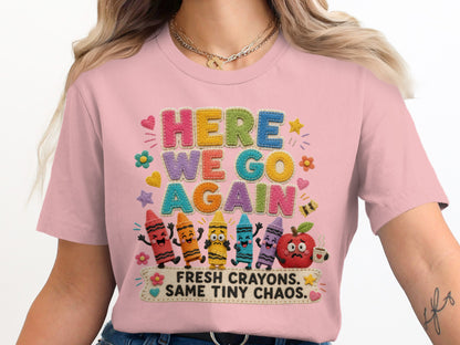 Pink t-shirt with "HERE WE GO AGAIN FRESH CRAYONS. SAME TINY CHAOS." text and cartoon crayons.